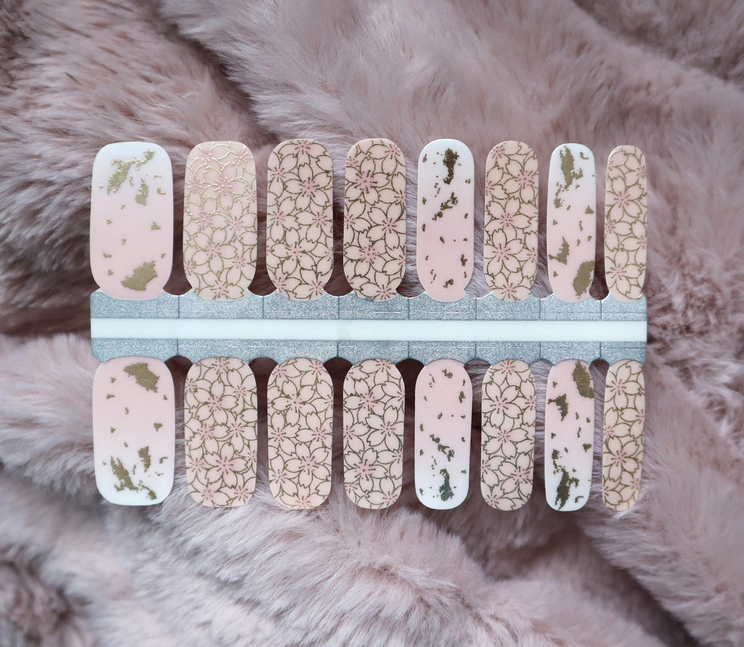 Ongles en gelée semi-transparents roses avec motif de fleurs dorées métalliques et motifs en marbre