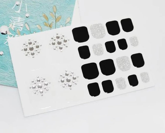 Pedicure Silver Dots avec fond clair, enveloppements d'ongles d'orteil à paillettes noires et argentées