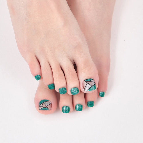 Paillettes vert émeraude avec des ongles d'orteil argentés et transparents