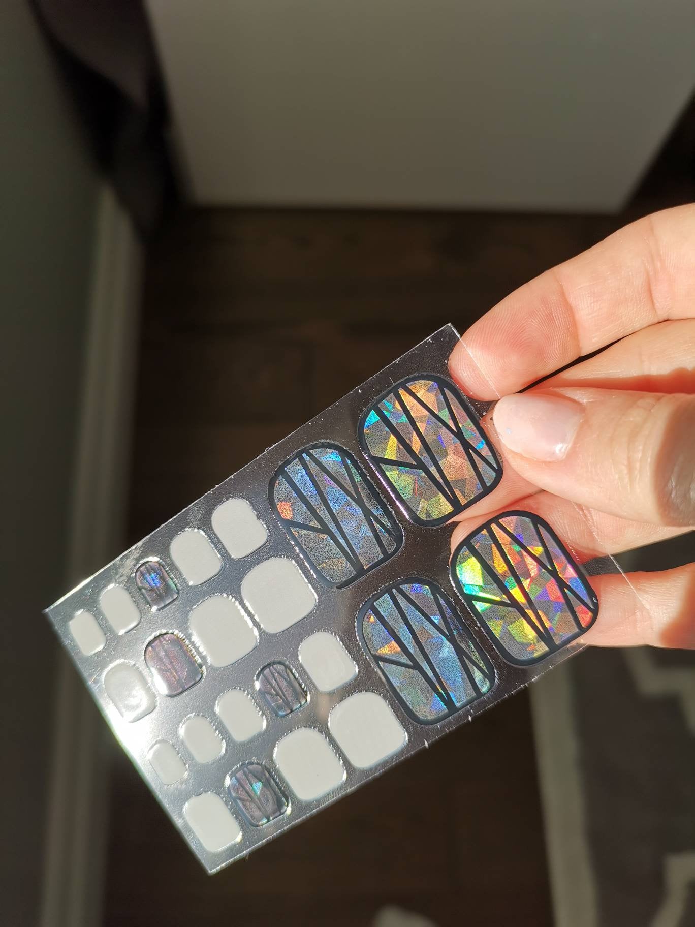 Effet de verre obturateur irisé holographique avec des ongles d'orteil solides gris